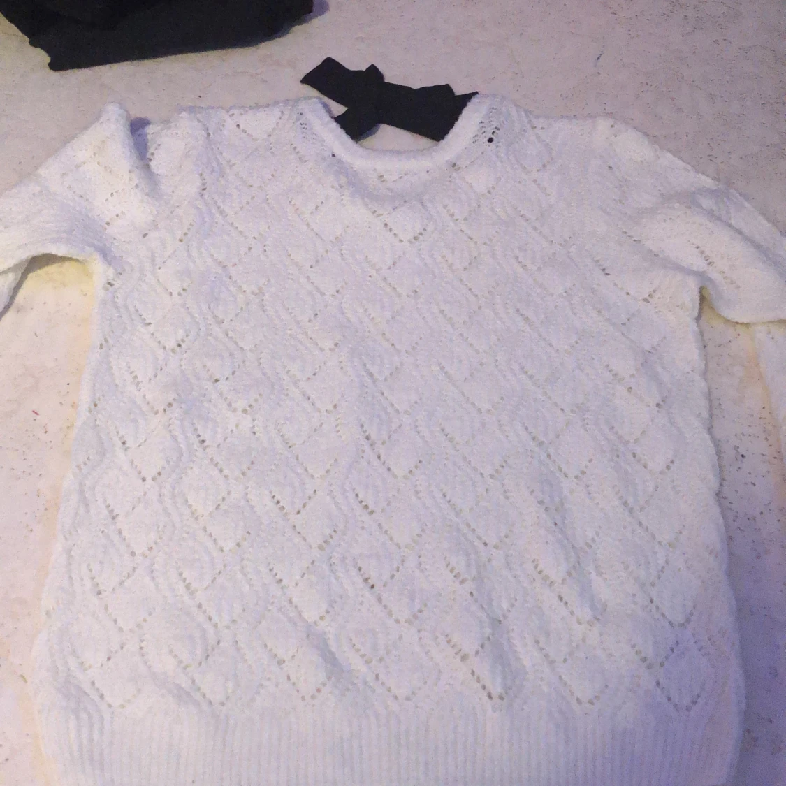 vitt stickad tröja med en rosett