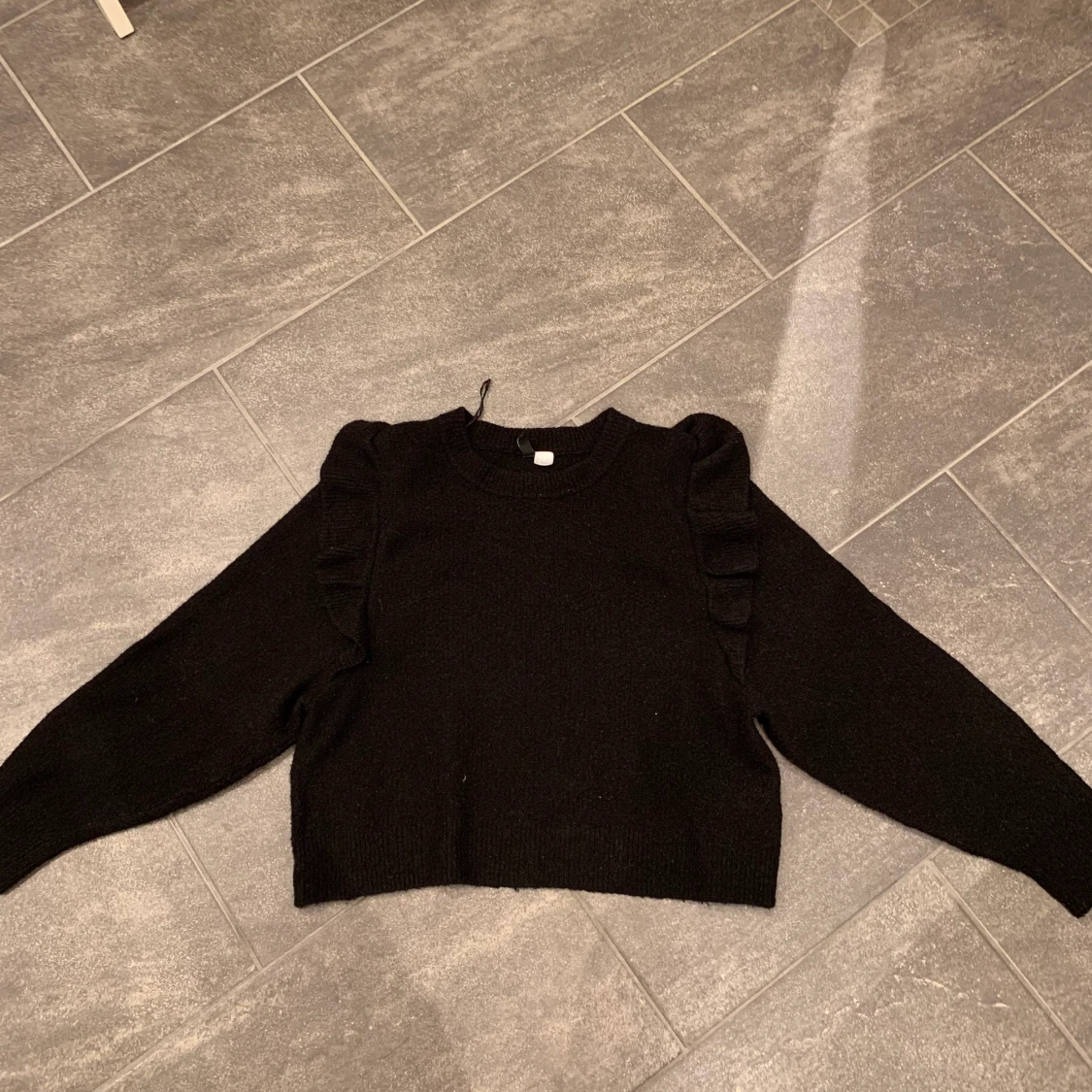 Svart tröja med volang 