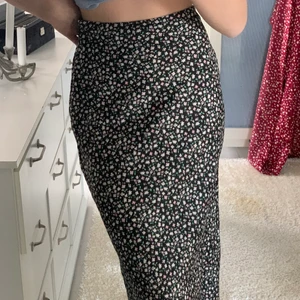 Kjol  - Säljer min svarta siden kjol med blommor från hm säljer den för att den tyvär inte kommer till andvändning, den är bara använd en gång, jag köpte den för 250 men säljer för 100 kr köparen står för frakten 