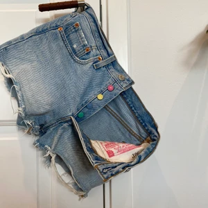 501 shorts - Säljer mina Levis 501 shorts pga storleken. Ljus tvätt med slitningar och färgade knappar. Använda men i bra skick!