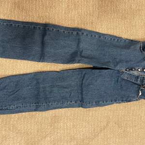 Skitsnygga blåa jeans från Levis i modellen ribcage straight i storlek 29 slutar vid foten på mig som är 174 cm