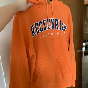 Colorado hoodie - Orange hoodie med trycket ”Breckenridge, Colorado”, storlek S. Köpt second hand i England men superfint skick. Bud från 100 kronor i kommentarerna, avslutas 25/2! Öka med minst 10 kronor. Frakt tillkommer