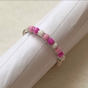 Ring  - Pris: 25 kr   Färg: ljusrosa, mörk rosa, vit   Material: silvrig ståltråd (ej äkta silver), vit, ljusrosa, mörk rosa plast pärlor  Storlek: Omkrets ca 51 mm   Diameter ca 18  mm  ❗️Frakt ingår ej❗️ Skriv privat vid köp!💞