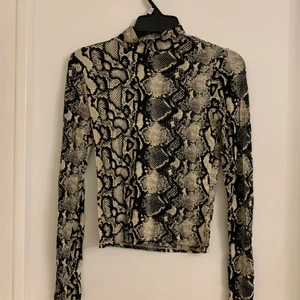 Ormskinnmönstrad topp - Med krage. Från Gina Tricot. Strl S. 