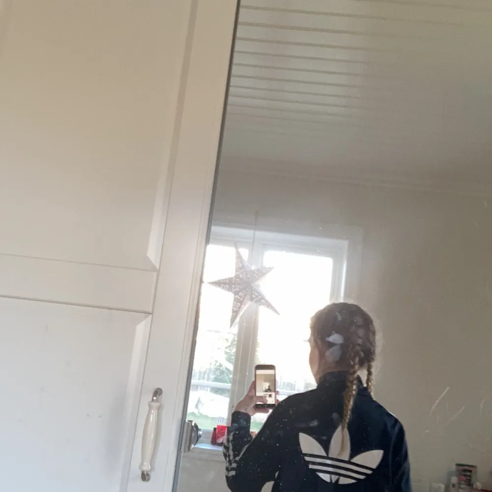 Tröjan har ett adidas märke på ryggen. Hoodies.