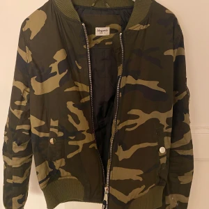 Bomberjacka - Bomberjacka i miltär som är i fint skick. Blev tyvärr bara använd några enstaka gånger innan den fick hänga i garderoben då jag tröttnar på mönster lätt. Storleken är L, men skulle mer säga att det är en M.