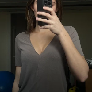 Urringad ribbad t-shirt - Beige/grå v-urringad t-shirt från ZARA😍 Jättefin vardagströja som är använd fåtal gånger, som ny! Skön och luftig t-shirt till vår/sommar. Köparen står för frakten:)