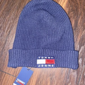 Helt ny Tommy Hilfiger mössa! - Helt ny ribbstickad mössa från Tommy Hilfiger. Originallapp sitter kvar! Aldrig använd, nypris 599kr Mörkblå färg