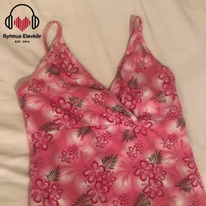 Rosa klänning med blommor - Rosa klänning i okänd storlek. Säljs av Rytmus Stockholms Elevkår, alla kläder som säljs har skänkts utav elever på Rytmus och de pengar som samlas in från klädinsamlingen ges oavkortat till WWF. Ta chansen och köp fina kläder second hand och bidra på samma gång till att bevara miljön!