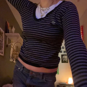 Lacoste tröja - Randig lacoste tröja som jag klippt två hål i vid tummarna, storleken är L men skulle säga att den passar de flesta storlekar för den är strectchig hör av dig fler bilder:)