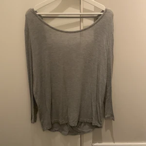 Tröja med öppen rygg - Långärmad grå tröja med djup urringning i ryggen. 