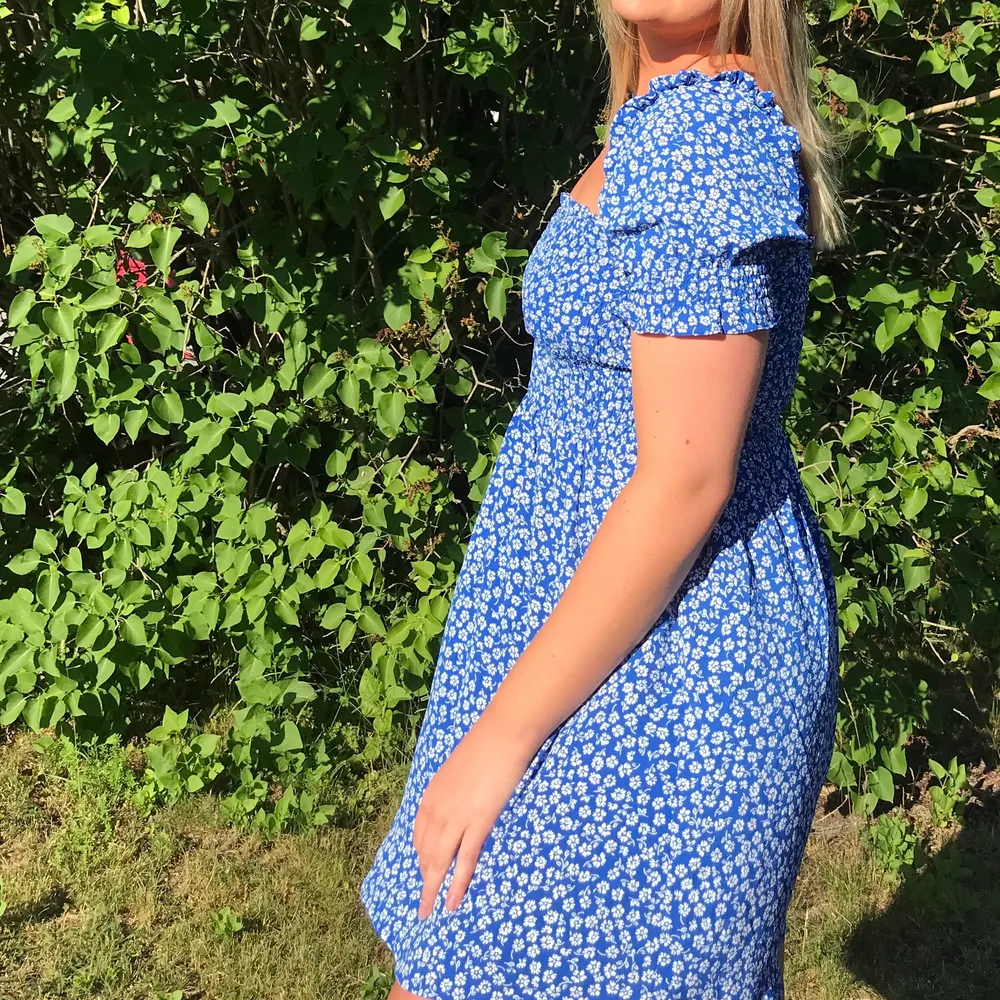 Kort blommig klänning i härlig klarblå färg. Inköpt sommaren 2020 och använd vid 1 tillfälle. . Klänningar.