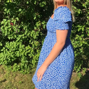 Blommig klänning - Kort blommig klänning i härlig klarblå färg. Inköpt sommaren 2020 och använd vid 1 tillfälle. 