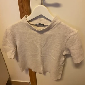 Tröja  - Kortärmad tröja med beigh färg. Snygg i materialet och använd ett fåtal gånger 