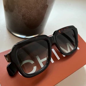 Chimi solglasögon  - Säljer mina superfina chimies som är inköpta förra året och går ej att få tag på längre, tyvärr kommer dem ej till användning vilket är synd. Box, fodral ingår, glaset är mörkat med en ton av grönt och ramen runt är brun/svart flammig. Nypris 1400kr