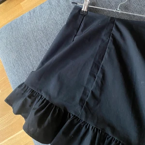 Kjol Svart - Säljer min fina svara kjol. Ett måste till våren. Volang nedtill samt en söm med snörning. Exklusive frakt