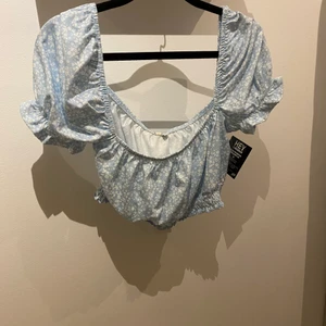 Sommartopp  - Hej! Säljer nu denna fina blommiga blåa topp från Nelly. Den är köpt i ett sett tillsammans med en kjol! Men jag köpte bara settet för kjolen så tröjan blev liggandes! 💗den är jätte fin men passade inte rikigt på mig!💘 den är helt oanvänd endast provad! Kan mötas upp i Ronneby, Karlskrona Eller Karlshamn! Kan även skickas! 💘