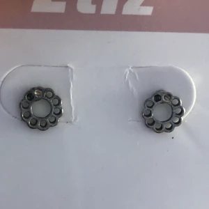 Örhängen  - Runda blommörhängen. Bredd 1,8 cm. Köpta på H&M. Aldrig använda. Vet ej vilket material det är. Såklart så desinfekteras örhängena innan de skickas iväg.