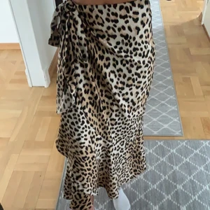 Fin leopard kjol strl 36 - 🤎jätte fin lång kjol i leopard mönster. Knytning på ena sidan och volanger längst ned. Finns en extra knapp på innersidan (se bild 3). Den är i storlek 36/S men eftersom att man knyter den kan man knyta den hårdare så den passar XS oxå. Perfekt att använda en fin sommardag men säljer den då den inte används längre! 💕skriv vid frågor, priset kan diskuteras