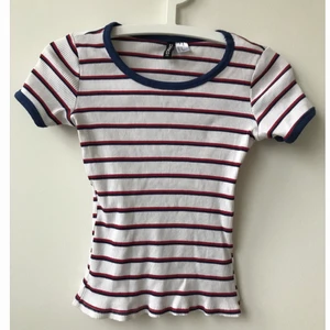Randig topp - blå, röd, vit. Storlek XS - Fin topp från H&M, storlek XS. Sitter ganska tight och går lite över byxlinningen på mig. Knappt använd!