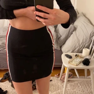 Tight kjol med streck - En tight kjol med ett vitt och rött streck. Använd några fåtal gånger men inget som syns på kjolen (som ny) storlek xs 