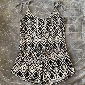 Byxdress - Snygg och somrig byxdress med svart/vitt mönster. Snörning i midjan och justerbara knyt-axelband. 