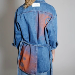 Smiley Jean Jacket - Skjortjacka med oranga detaljer i ”smileymotiv” och knytning i midjan. Ursprungligen från H&M som är omgjord av Scannable UF. Genom att skanna en QR-kod som finns fäst på plagget kan du läsa mer om materialet och dess miljöpåverkan!✨✨