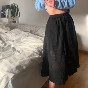 Svart kjol - Säljer denna kjol från ARKET, aldrig använd och nypris var  500kr. Svår att ge rättvisa på bild men den är helsvart med små hål, såå fin på sommaren till en stickad tröja och birkenstock!