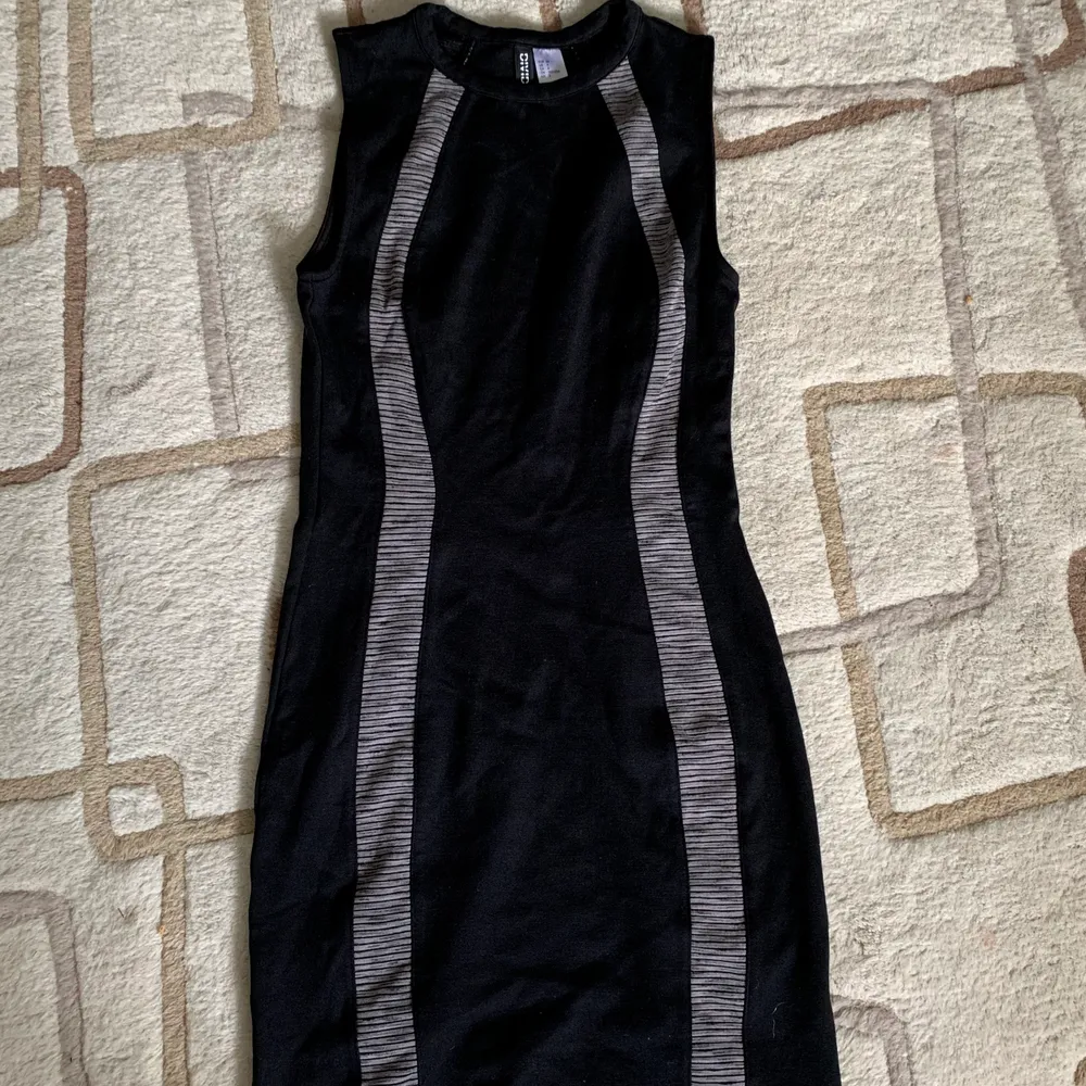 Svart klänning från HM med två gråa band insydda fram och bak. Ger en mer kurvig figur. Använd fåtal gånger. . Klänningar.