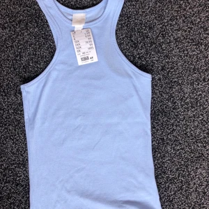 Linne - Säljer detta jättefina & sköna blåa linne från hm. Jag hittade ett annat som passade mig bättre vilket gjorde att jag ville sälja. Aldrig använt endast provat, lappen sitter kvar. Det är ett blått linne som går i lila ton. Mer av ett ”flowy” matrieal vilket är jätteskönt. Jag är xs & det passar jättebra på mig så skulle säga att de är xs. Orginal pris 99 kr. Jag tar endast swish & köparen står för valfri frakt, frakten ingår inte i priset🌸