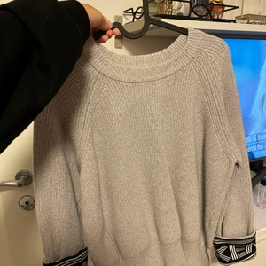 Kenzo tröja - Plagget är köpt på tara i Kungsmässan och är använd ett fåtal gånger. Den är grå med snygg detalj i ärmarna. Den är i storlek S men passar lika bra för er som bär storlek M.