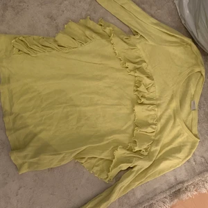 S - Ett helt vanlig gul tröja med volanger 