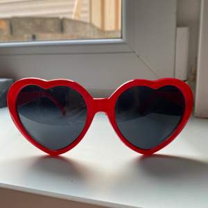 Hjärtformade röda solglasögon, använda en gång. 