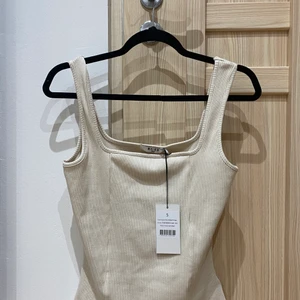 Linne NA-KD Strl S/M - Sandbeigt linne med rektangulär urringning från NA-KD.  Oanvändt! Storlek S, men passar nog S/M. Kontakta gärna vid frågor!!💕