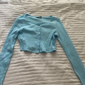 Blå croppad tröja - En superduper fin tröja med knappar som man kan knäppa upp om man vill