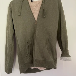 Grön Hoodie med teddyfleece i S  - Extremt skön och gosig hoodie med teddyfleece. Tyvärr är de ingen teddyfleece i armarna utan bara på resterande inkl luvan.                                                        Köparen står för frakten!