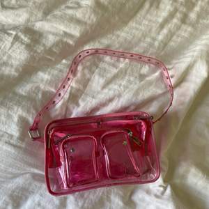 Säljer denna rosa genomskinliga väskan från Nunoo då den inte kommer till användning. Den är i nytt skick och endast använd en gång. Den är superfin och i deras mellan storlek! Ett längre band kommer också med väskan! Frakt tillkommer!❤️‍🔥