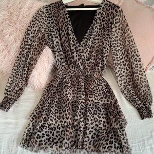 Klänning i leo  - Superfin klänning med volang och markering i midjan i leopardmönster. Endast använd en gång på ett födelsedagsfirande. Muddar i ärmar och fin vringning. 