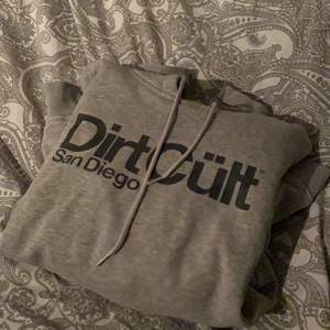 Grå dirtcult hoodie i bra skick. Använd hyfsat mycket men enda negativa är ett litet hål på vänster axel (se bild) Storlek L men väldigt liten i storlek, passar mer M/S. Nypris 699kr men säljer för 150kr. Köparen står för frakt.