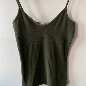 Ribbad topp  - Det är en ribbad grön topp som är för liten så har aldrig kommit till användning 