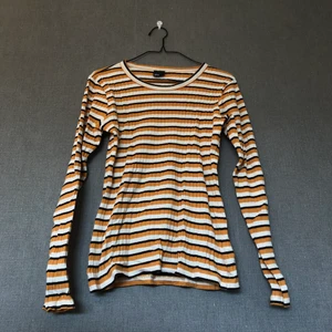 Ribbad tröja i retrostuk - • Mjuk & härlig tröja i retrostuk, 70’s vibes. Ribbad & mycket fin i färgerna, härlig orange nyans. Matchas lätt till mycket! • Storlek: M, längre/vanlig modell • 95% bomull & 5% elastan • Knappt använd, mycket fint skick! • +Frakt: 51kr spårbart 