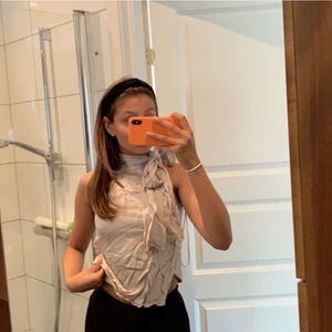 Topp - Söljer denna metalik aktika färgen på denna topp. Den har en knytning runt halsen som man kan knyta på olika sett. 