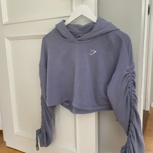 Gymshark croppad hoodie - Säljer pga används för lite. Men är sååå fin och bekväm! Croppad hoodie i jättefin färg från Gymshark. I väldigt fint skick