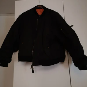 Bomberjacka MA1 - En svart äka bomberjacka MA1 ifrån märket MFH. Oranget innerfoder. 