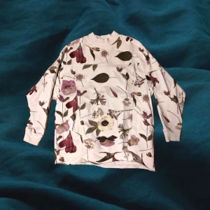 Blommig tjock-tröja - Oversized, blommig tjocktröja med fickor. Cropped längst ner, men inte kort alls.