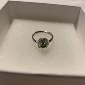 Fin silver ring med grön sten i mitten och diamanter runt 