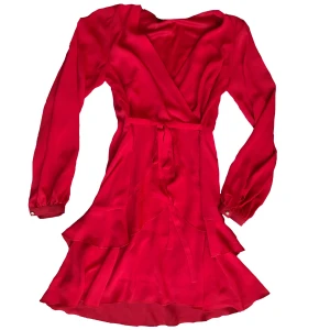 Röd flowy midiklänning  - Supersöt flowy midiklänning med knytning i midjan. Fina knappar i ärmarna. Fint skick.