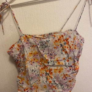 Sommartopp - En blommig sommartopp i fina färger! Knytband. Bra skick. Storlek M. Finns på andra sidor också 🥰