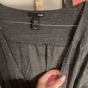 Knälång klänning - Knälång klänning med v-ringning och knyt i midjan, storlek 40 men är fin oversize/längre från och med storlek 36 också.   Perfekt vinterklänking till event eller jobb med en underklänning.   Fint skick 