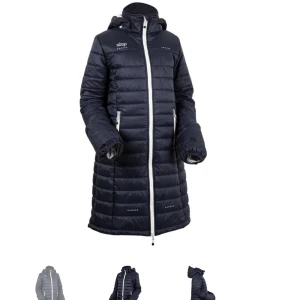 Junior lång ridkappa uhip  - Praktisk ridkappa i marin blå. Avtagbar luva. Handvärmarna vid ärmarna går att fälla ned över handen och skyddar. Lång sprund baktill gör att man kan rida med kappan utan att den är i vägen. Väldigt bra skick. Nypris 1500 kr